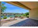 Expansive backyard view featuring a picturesque lake, lush landscaping, and covered patio area at 42485 W Abbey Rd, Maricopa, AZ 85138