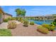Stunning lakefront backyard with vibrant plants, manicured bushes, and easy access to the water at 42485 W Abbey Rd, Maricopa, AZ 85138