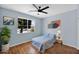 Comfortable bedroom features soft blue walls, a ceiling fan, and a well-lit window at 42485 W Abbey Rd, Maricopa, AZ 85138