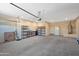 Spacious two car garage with overhead storage, shelving, and room for vehicles and projects at 42485 W Abbey Rd, Maricopa, AZ 85138