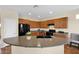 Well-lit kitchen featuring a large island with sink and black appliances at 42485 W Abbey Rd, Maricopa, AZ 85138