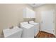 Functional laundry room features modern appliances, ample cabinet storage, and a utility sink at 42485 W Abbey Rd, Maricopa, AZ 85138