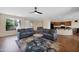 Spacious living room open to the kitchen with modern furnishings, wood floors, and ample natural light at 42485 W Abbey Rd, Maricopa, AZ 85138