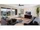 Cozy living room with large windows overlooking a serene lake, comfortable seating, and natural light at 42485 W Abbey Rd, Maricopa, AZ 85138