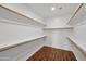 Walk-in closet with shelves and wooden floors at 42485 W Abbey Rd, Maricopa, AZ 85138