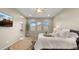 Tranquil bedroom featuring a TV, large windows, and an arched doorway leading to the ensuite bathroom at 4341 E Evelyn St, Gilbert, AZ 85295