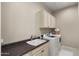 Well-organized laundry room with a sink, storage cabinets, and modern washer and dryer at 4341 E Evelyn St, Gilbert, AZ 85295