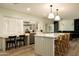 Bright kitchen featuring island with seating, white cabinetry, and a window over the sink at 547 W Orangewood Ave, Phoenix, AZ 85021
