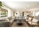 Spacious living room features modern gray sectional, natural light, and an open concept design at 547 W Orangewood Ave, Phoenix, AZ 85021