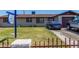 Modest single-story home with a brown roof, a blue car parked on the driveway, and a small fenced front yard at 6063 W Earll Dr, Phoenix, AZ 85033