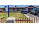 Modest single-story home with a brown roof, a blue car parked on the driveway, and a small fenced front yard at 6063 W Earll Dr, Phoenix, AZ 85033