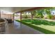 Relaxing covered patio overlooking a lush, green backyard, perfect for outdoor entertaining and leisure at 6232 N 88Th Ave, Glendale, AZ 85305