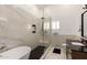 Modern bathroom featuring a glass shower, standalone tub, and sleek marble countertops at 6232 N 88Th Ave, Glendale, AZ 85305