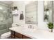 Bright bathroom featuring a glass enclosed shower and a wood vanity with white countertop, and a decorative mirror at 6232 N 88Th Ave, Glendale, AZ 85305