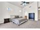 Bright bedroom with neutral carpet and walls, a ceiling fan, and windows for natural light and view of the backyard at 7532 E Sierra Morena Cir, Mesa, AZ 85207