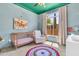 Bright Bedroom featuring a wooden crib, rocking chair, and view from the window at 7532 E Sierra Morena Cir, Mesa, AZ 85207