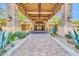 Luxurious clubhouse entrance with a brick walkway, lush landscaping, and stone columns at 7532 E Sierra Morena Cir, Mesa, AZ 85207