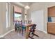 Cozy dining area with a wooden table set for six, nestled next to a window offering backyard views at 7532 E Sierra Morena Cir, Mesa, AZ 85207