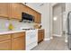 Bright kitchen features white appliances, wooden cabinetry and tile flooring, complemented by ample countertop space at 7532 E Sierra Morena Cir, Mesa, AZ 85207
