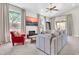 Comfortable living room with TV, large windows, red chair, and neutral-toned carpet at 7532 E Sierra Morena Cir, Mesa, AZ 85207