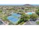 Aerial view of well-maintained tennis courts next to the pool area, offering residents recreational opportunities at 7532 E Sierra Morena Cir, Mesa, AZ 85207
