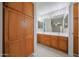 Bathroom with dual sinks, wood cabinets, vanity lighting, and tile flooring at 7549 W Yucca St, Peoria, AZ 85345