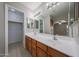 Bathroom with dual sinks, wood cabinets, vanity lighting, and tile flooring at 7549 W Yucca St, Peoria, AZ 85345