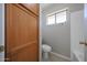 Bathroom featuring a toilet, window and wood cabinet with storage at 7549 W Yucca St, Peoria, AZ 85345