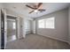 Carpeted bedroom featuring ceiling fan, closet with shelving, and view into the bathroom at 7549 W Yucca St, Peoria, AZ 85345