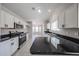 Well-lit kitchen features white cabinets, black countertops, and a stainless steel range oven at 7549 W Yucca St, Peoria, AZ 85345