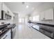 Spacious kitchen featuring white cabinets, black countertops, and stainless steel appliances for a modern touch at 7549 W Yucca St, Peoria, AZ 85345