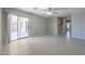 Spacious living room with neutral tile, sliding glass door, and a ceiling fan at 7549 W Yucca St, Peoria, AZ 85345