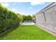 Backyard view of a pool, patio, and manicured lawn bordered by mature hedges and trees at 8007 E Del Tesoro Dr, Scottsdale, AZ 85258