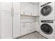Well-equipped laundry room with modern washer, dryer, ample storage, and counter space for folding at 8007 E Del Tesoro Dr, Scottsdale, AZ 85258