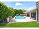 Beautiful backyard pool surrounded by lush greenery and flagstone decking with covered patio at 8007 E Del Tesoro Dr, Scottsdale, AZ 85258