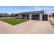 Charming single-story home with a well-manicured lawn, a gray garage door and a walkway to the front door at 8022 E Columbus Ave, Scottsdale, AZ 85251