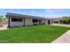 Well-maintained single story house with a green lawn, dark trim, and mature landscaping at 8022 E Columbus Ave, Scottsdale, AZ 85251