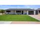 Inviting single-story home with a lush green lawn, dark trim and a modern front entrance at 8022 E Columbus Ave, Scottsdale, AZ 85251