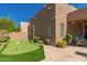 Backyard featuring putting green with lush greenery and privacy wall at 8324 E Cactus Wren Rd, Scottsdale, AZ 85250