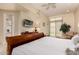 Bedroom showcasing a wooden sleigh bed, large window, TV, and access to the outdoor patio at 8324 E Cactus Wren Rd, Scottsdale, AZ 85250