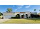 Charming, light-colored single-story home featuring a well-manicured lawn and covered entryway at 8413 E Belgian Trl, Scottsdale, AZ 85258