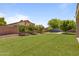 Spacious backyard with an artificial grass lawn, lush landscaping and privacy fence at 8621 W Morten Ave, Glendale, AZ 85305