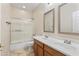 Bright bathroom featuring double sinks, wood cabinets, a shower, and tile floors at 8621 W Morten Ave, Glendale, AZ 85305