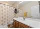 Well-lit bathroom featuring a vanity with a white countertop, storage cabinets, and shower with decorative curtain at 8621 W Morten Ave, Glendale, AZ 85305
