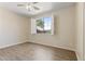 Bright bedroom featuring hardwood floors, a ceiling fan, and a window with white shutters at 8621 W Morten Ave, Glendale, AZ 85305