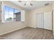 Bedroom features wood floors, a ceiling fan, large window with shutters and a closet with folding doors at 8621 W Morten Ave, Glendale, AZ 85305