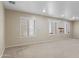 Spacious bonus room with plush carpeting, plantation shutters, and neutral paint colors at 8621 W Morten Ave, Glendale, AZ 85305