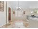Elegant dining area featuring tile floors, shuttered window, decorative lighting and adjacent to another room at 8621 W Morten Ave, Glendale, AZ 85305