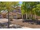 Beautiful two-story home with a three-car garage surrounded by mature trees and well-kept desert landscaping at 8621 W Morten Ave, Glendale, AZ 85305