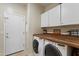 Functional laundry area with washer, dryer, cabinets, and convenient access to the exterior at 8621 W Morten Ave, Glendale, AZ 85305